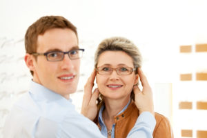 man and woman in optician shop looking into camera