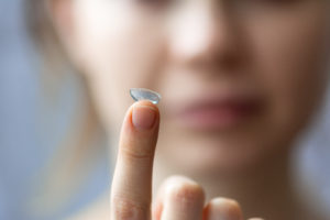 girl holding soft contact lenses close-up macro