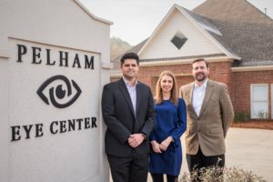 Three optometrists pose outside the practice they own together in Pelham, Alabama. 