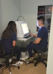 Kevin Soong, OD, performs diagnostic testing using an OCT in the office of ROB Professional Editor Laurie Sorrenson, OD, FAAO